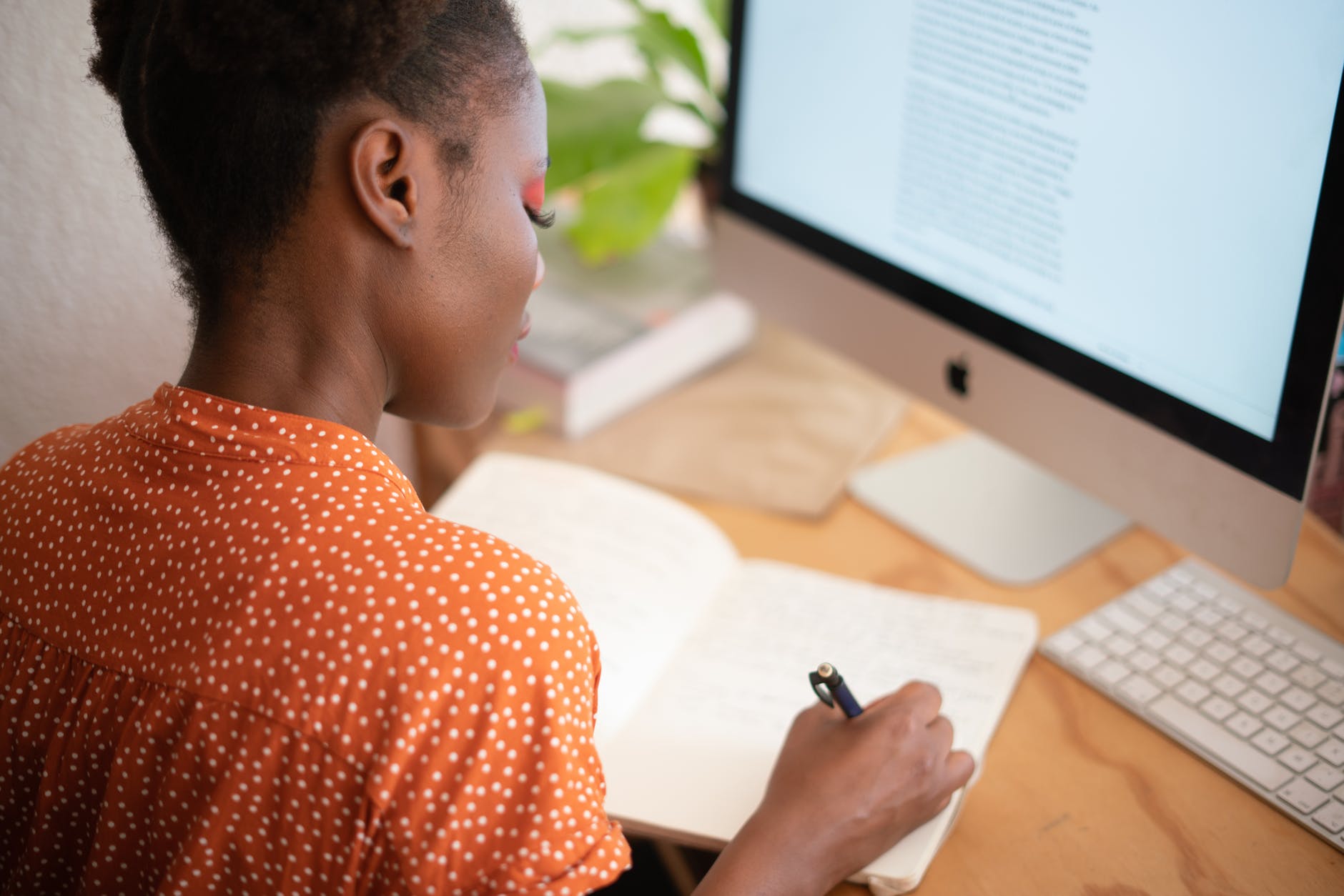 Black woman sitting at desk working from home.